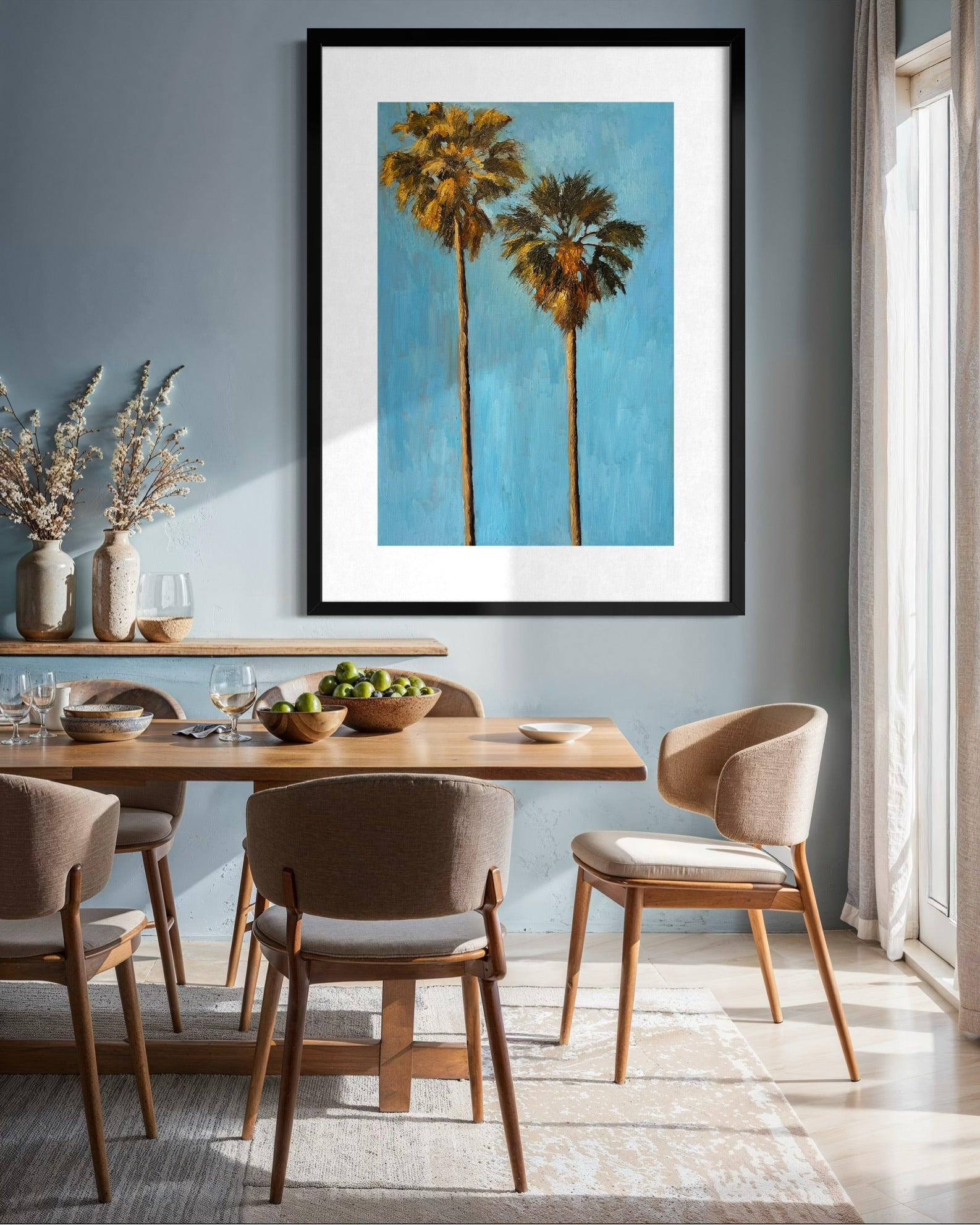 Dining room with a wooden table and chairs, featuring a framed artwork of palm trees on the wall.