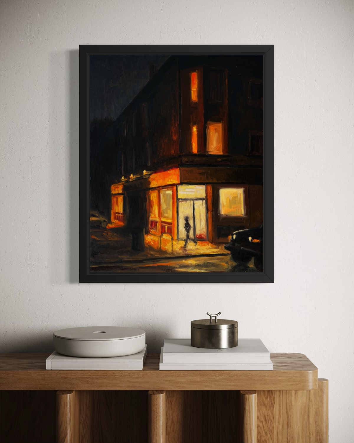 "Corner Store" original oil painting by John Wellington — black floater frame above a wooden sideboard
