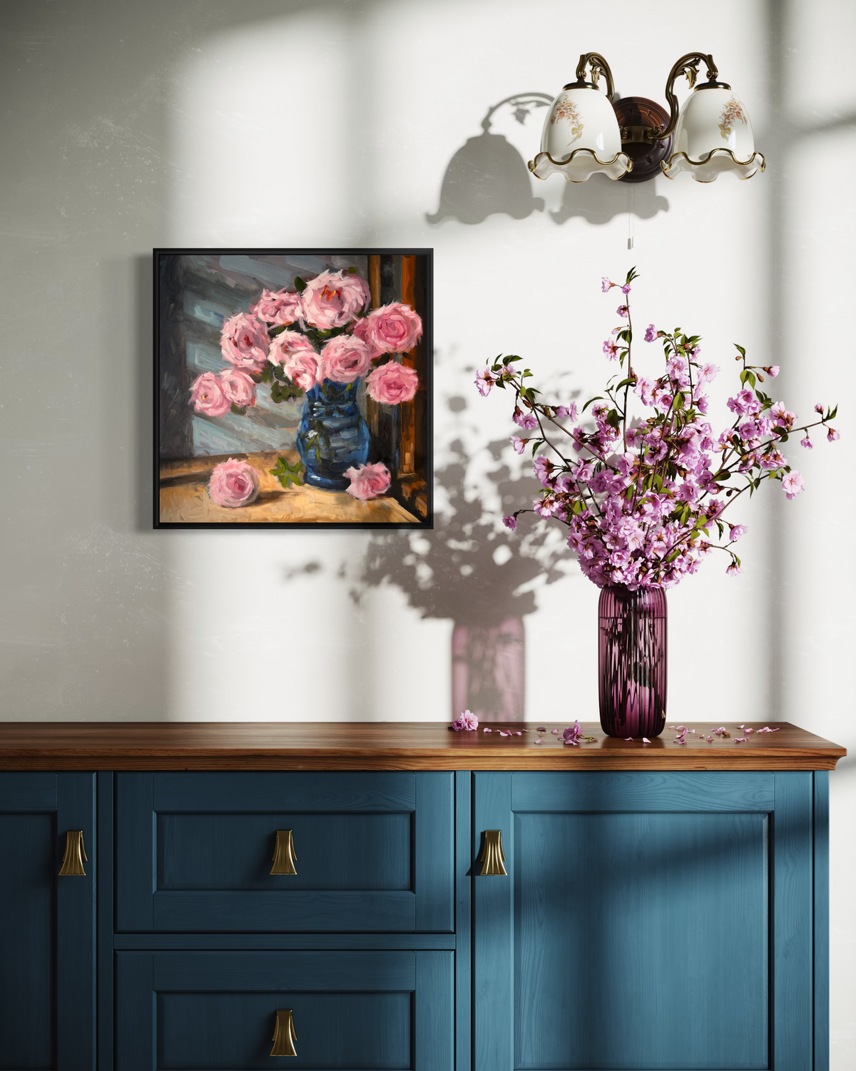 "Pink Roses" original oil painting by John Wellington — framed in soft window light above a navy sideboard